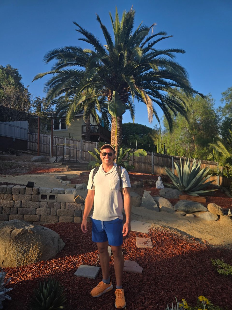 John Krause standing beneath a mature Canary Island date palm at his Old Escondido property