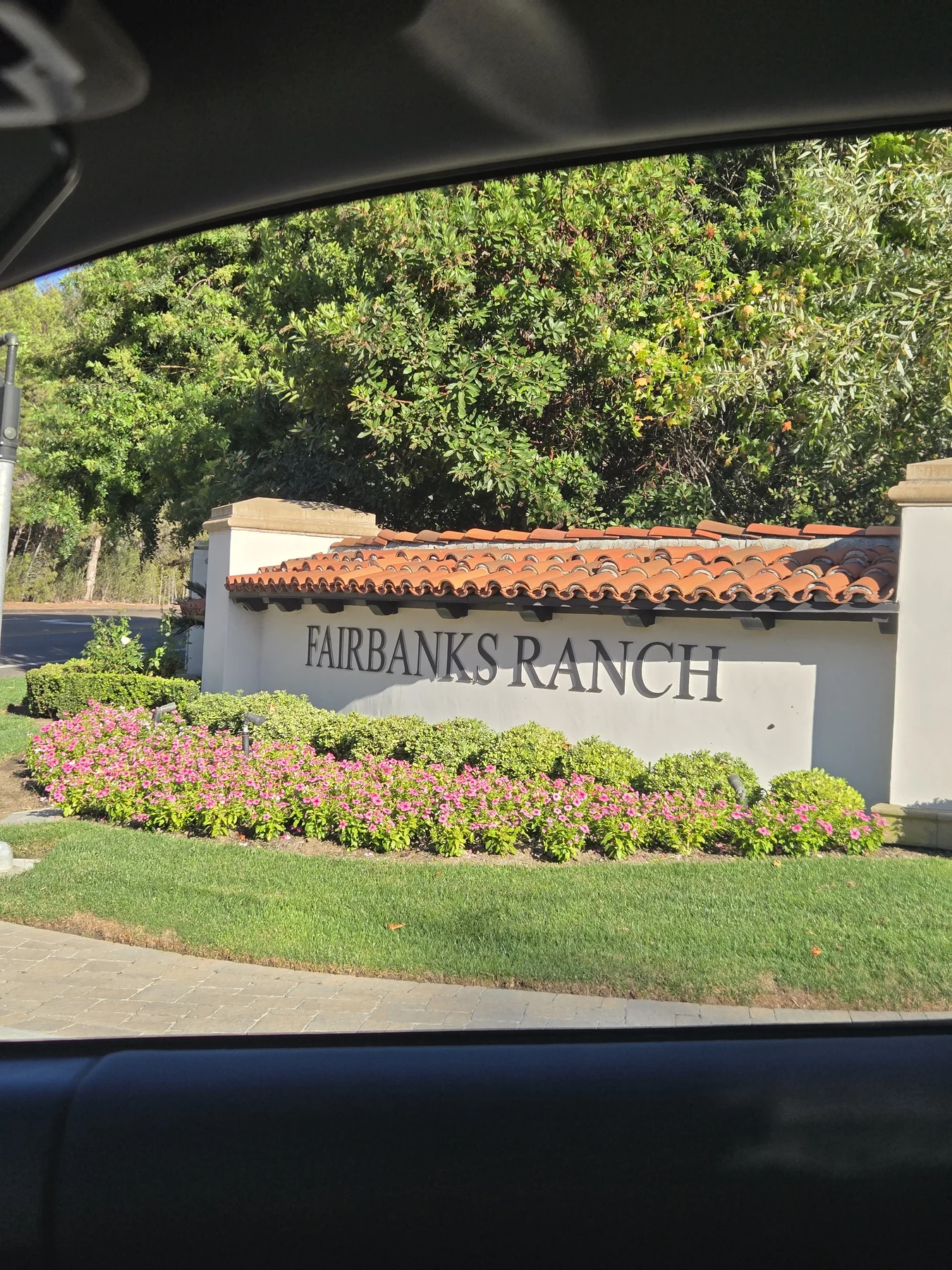 Fairbanks Ranch entrance monument surrounded by flowers and mature landscaping